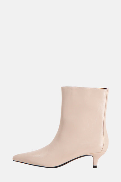 Bottines beige d'Astrid Black Label, avec un nez pointu et une semelle fine en vue de dos.