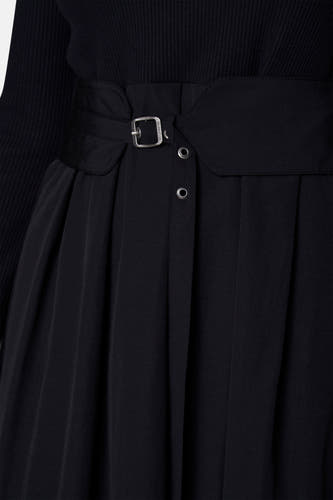 Zwarte riem van denim van Astrid Black Label, met zilverkleurige gesp en plooien aan de rok.
