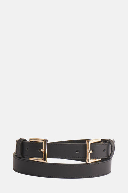 Ceinture noire d'Astrid Black Label avec boucles dorées, posée sur un fond blanc.