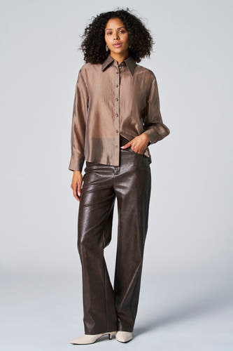 Blouse taupe à longues manches d'Astrid Black Label, avec fermeture à boutons et portée avec une jupe en cuir.