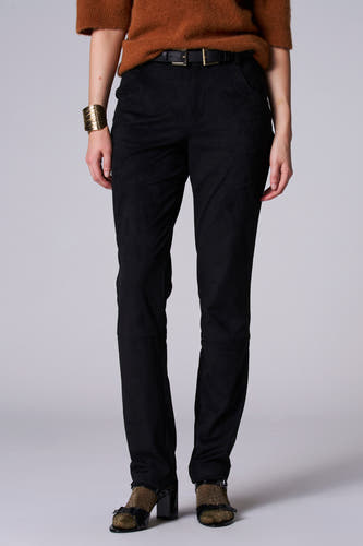 Zwarte broek van Astrid Black Label, met een gladde textuur, gecombineerd met een bruine trui, gouden armband en open schoenen.
