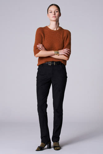 Pantalon noir d'Astrid Black Label, avec une ceinture en cuir, associé à un pull marron et un bracelet doré.