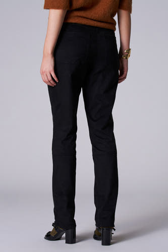 Zwarte broek van Astrid Black Label, gezien van achteren, met zichtbare naden en details, gecombineerd met een bruine trui en gouden armband.
