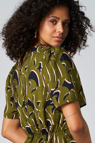Blouse verte avec manches trois-quarts d'Astrid Black Label, avec un motif abstrait de feuille en détails roses et noirs.