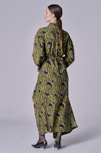 Vêtement vert avec longues manches d'Astrid Black Label, avec motif abstrait de feuille et ceinture à carreaux.