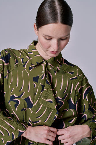 Robe verte à longues manches d'Astrid Black Label, avec un motif abstrait de feuille en rose et noir.