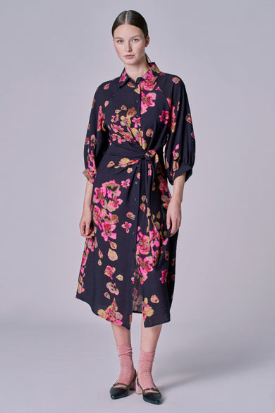 Zwarte jurk met lange mouwen van Astrid Black Label, voorzien van een roze bloemenpatroon en een geknoopt detail.