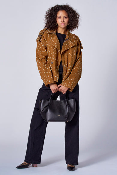 Manteau court brun d'Astrid Black Label à carreaux, associé à une poche main noire et des chaussures à talons compensés.