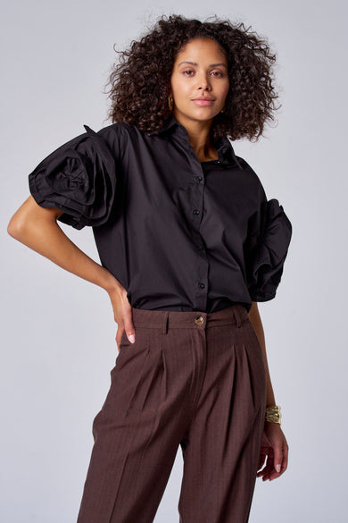 Zwarte blouse met korte mouwen van Astrid Black Label, met opvallende roze-details en bruine pantalon.
