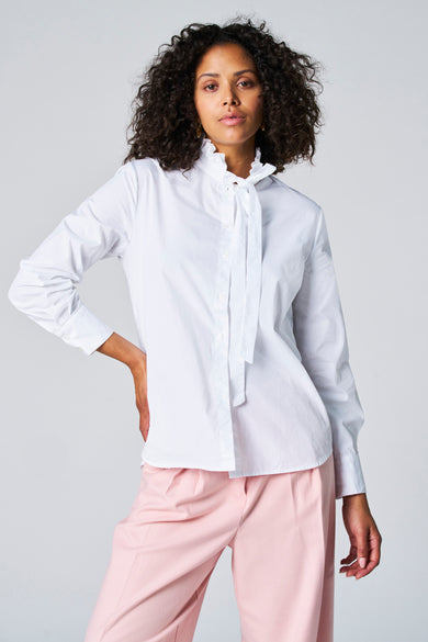 Witte blouse met lange mouwen van Astrid Black Label, met strikdetails en gecombineerd met een roze broek.