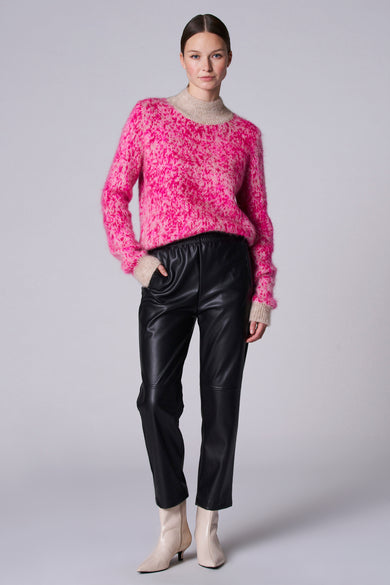 Pantalon noir d'Astrid Black Label, associé à un gilet rose et des bottines beige.