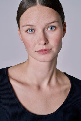 Robe noire avec des manches longues d'Astrid Black Label, portée par une femme à la peau claire et aux yeux bleus.