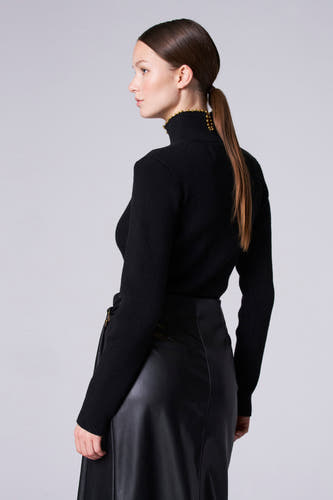 Blouson à col montant noir d'Astrid Black Label, avec des détails dorés décoratifs sur le col et une jupe en cuir noir lisse.