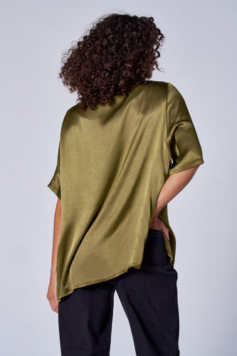 Blouse verte avec manches courtes d'Astrid Black Label, à texture brillante, associée à un pantalon noir.