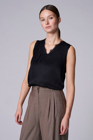 T-shirt noir Astrid Black Label avec détail en V sur les bords, porté par une femme.