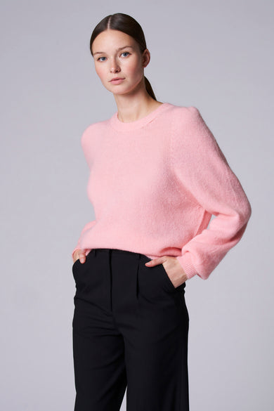 T-shirt rose avec col rond d'Astrid Black Label, porté avec un pantalon noir, dos.
