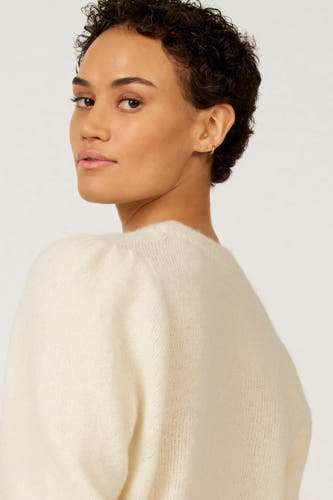Sweat-shirt écru d'Astrid Black Label, avec un col rond, une douce texture et des manches bouffantes.