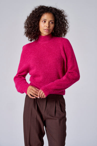 Veste rose Astrid Black Label portée avec un pantalon marron rayé, vue de derrière.