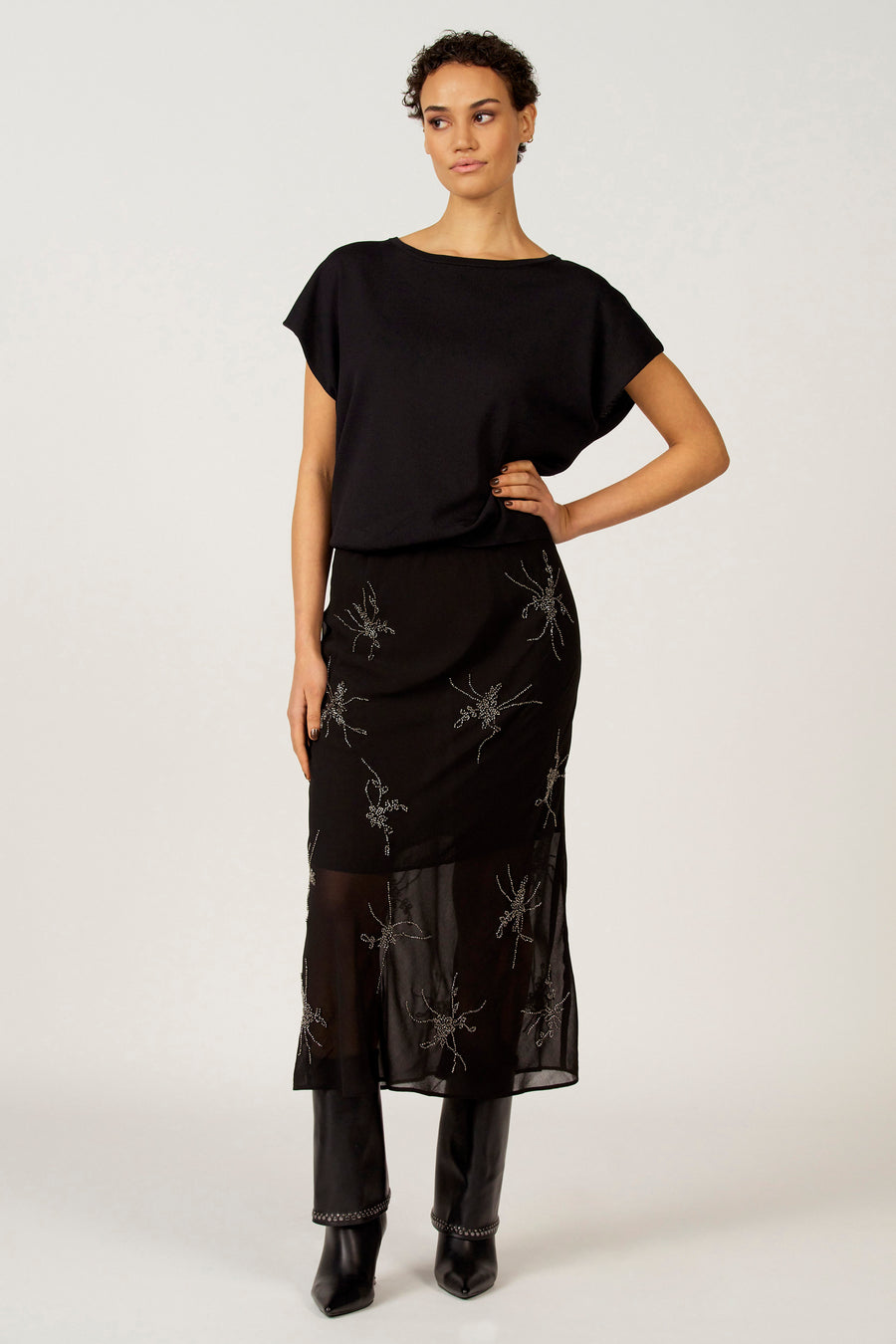 Robe noire d'Astrid Black Label, avec des motifs floraux brodés et une envers transparent.