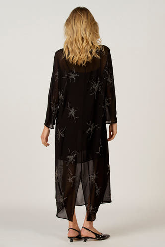 Robe noire avec des manches longues d'Astrid Black Label, dotée de décorations florales argentées, vue de derrière.