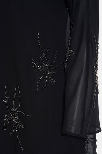 Robe noire avec longues manches d'Astrid Black Label, ornée de détails en perles dans des motifs floraux.
