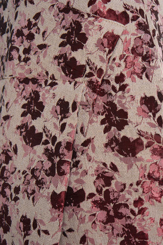Robe rose d'Astrid Black Label, avec un motif floral et une subtile texture.