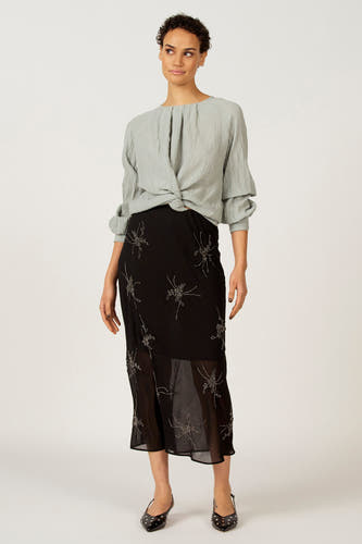 Blouse bleue à longues manches d'Astrid Black Label, avec détail de nœud plié et texture froissée.