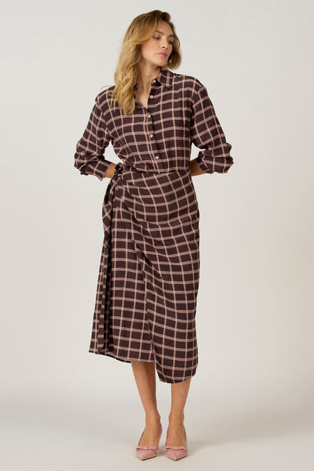 Robe brune à longues manches d'Astrid Black Label, avec un motif rayé, portée avec des chaussures roses à lacets.
