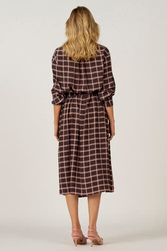 Robe brune à longues manches d'Astrid Black Label, avec un motif de carreaux et une ceinture élastique.