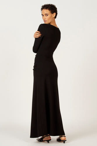 Robe noire à longues manches d'Astrid Black Label, modèle tailleur avec des plis sur les côtés.