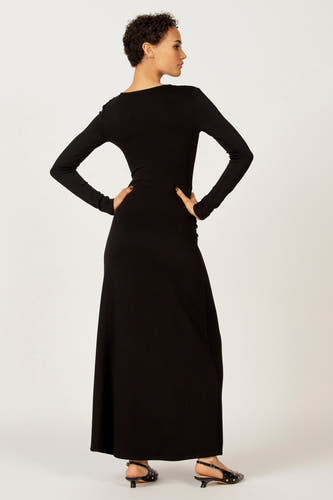 Robe noire à longues manches d'Astrid Black Label, modèle tailleur et terminé avec des chaussures noires.