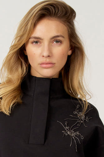 Pull noir Astrid Black Label, avec col montant et applications de perles décoratives.