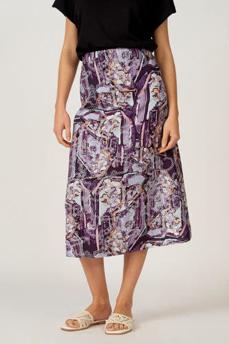 Jupe multicolore Astrid Black Label, avec un motif abstrait violet, associée à des sandales beiges.