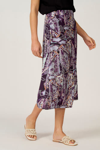 Multicolor rok van Astrid Black Label, met een abstract paars patroon, gecombineerd met beige sandalen.
