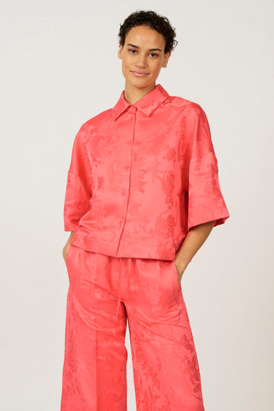 Blouse rose à manches trois-quarts d'Astrid Black Label, avec un motif fleuri et une jupe coordonnée.