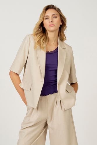 Blazer écru d'Astrid Black Label, vu de dos avec des manches courtes et un pantalon coordonné.