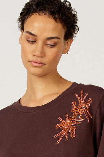 Bruin T-shirt met lange mouwen van Astrid Black Label, met bloemmotief van pailletten op de borst.