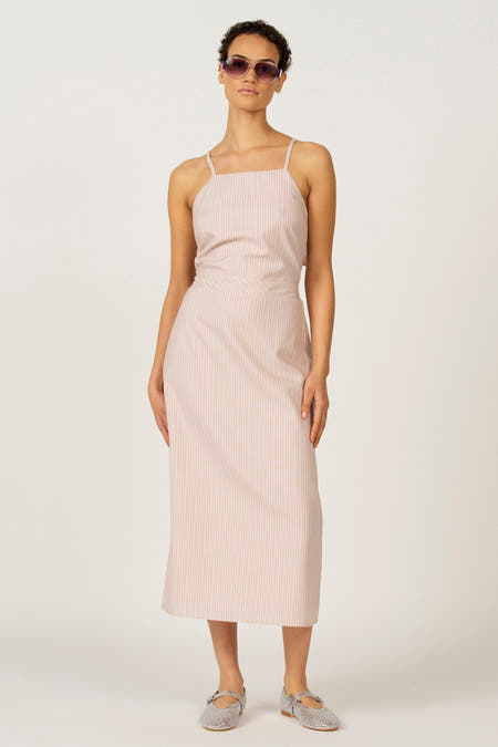 Roze kleedje zonder mouwen van Astrid Black Label, met verticale strepen en zilveren schoenen.
