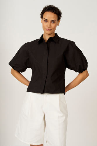 Chemisier noir à manches trois-quarts d'Astrid Black Label, montré de dos, combiné avec un pantalon blanc.