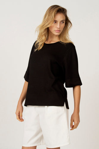 Zwart T-shirt met korte mouwen van Astrid Black Label, gecombineerd met een witte short.
