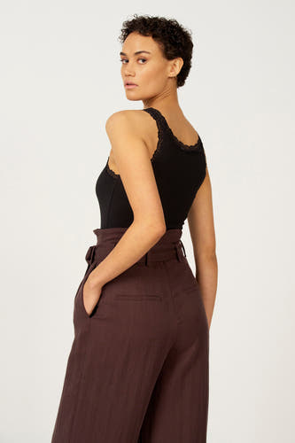 T-shirt noir Astrid Black Label, avec bord côte, associé à un pantalon marron.