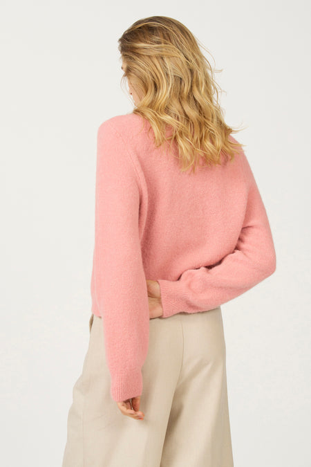 Roze trui en beige broek, achterkant.
