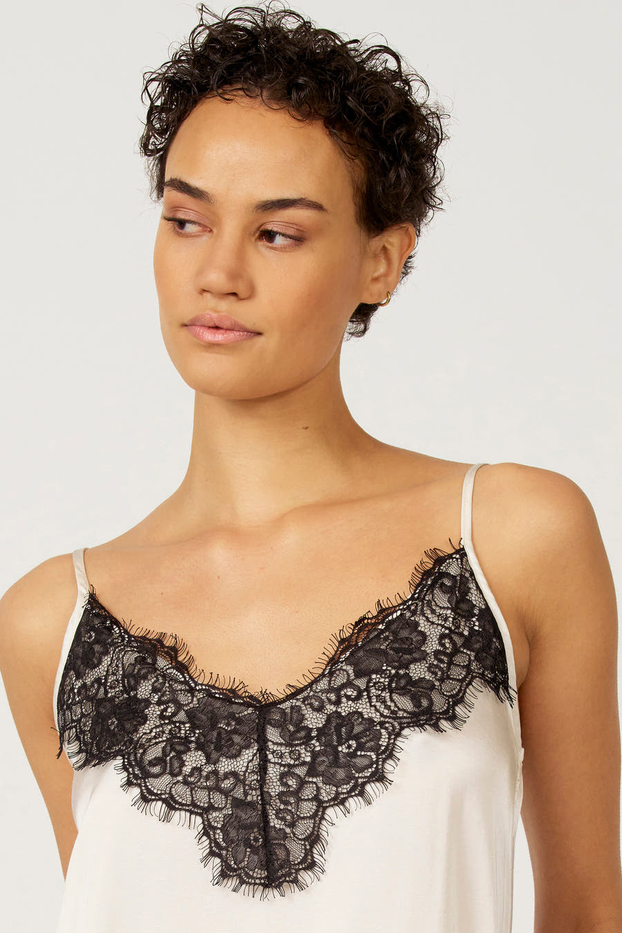 Blouse écru sans manches d'Astrid Black Label, finie avec des détails noirs.