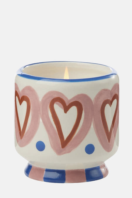 Bougie multicolore de PADDY WAX avec un motif de cœurs et des accents bleus sur un fond blanc.