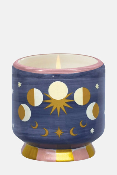 Bougie multicolore de PADDY WAX avec des phases de lune et un motif d'étoiles sur un fond bleu.
