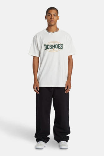 Jean boyfriend noir de DC SHOES, associé à un t-shirt blanc et une chaîne d'argent.
