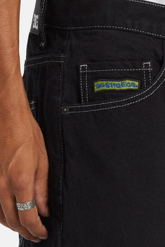 Jean décontracté noir en denim de DC SHOES, avec des surpiqures blanches et une patch logo brodée.