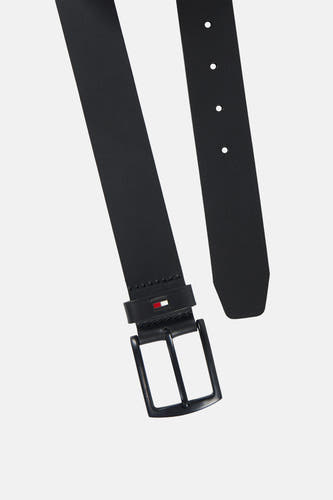Ceinture noire TOMMY JEANS, présentée en diagonale, avec une boucle métallique, des perforations et le logo drapeau sur le passant.