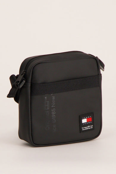 Sac à dos noir de TOMMY JEANS, avec une bande tissée et le logo de la marque.