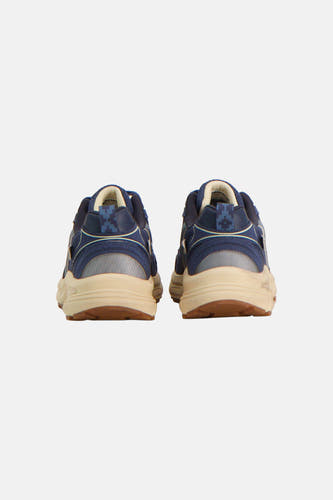 Arrière de baskets bleues AMERICANINO avec semelle intermédiaire crème et motif géométrique sur le talon.